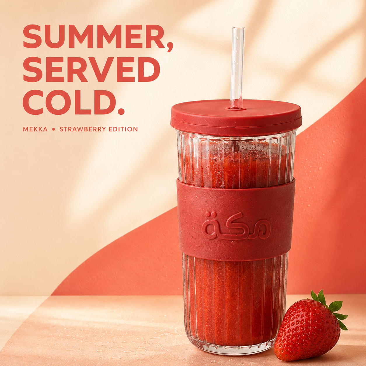 MAKKAH Strawberry Edition campaign key visual — ribbed glass cup with strawberry smoothie, red sleeve and fresh strawberry on a warm coral backdrop